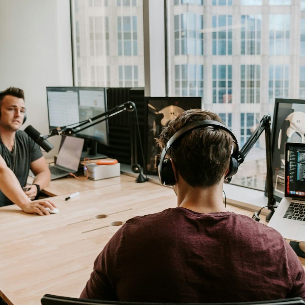Two podcasters recording an episode in a studio