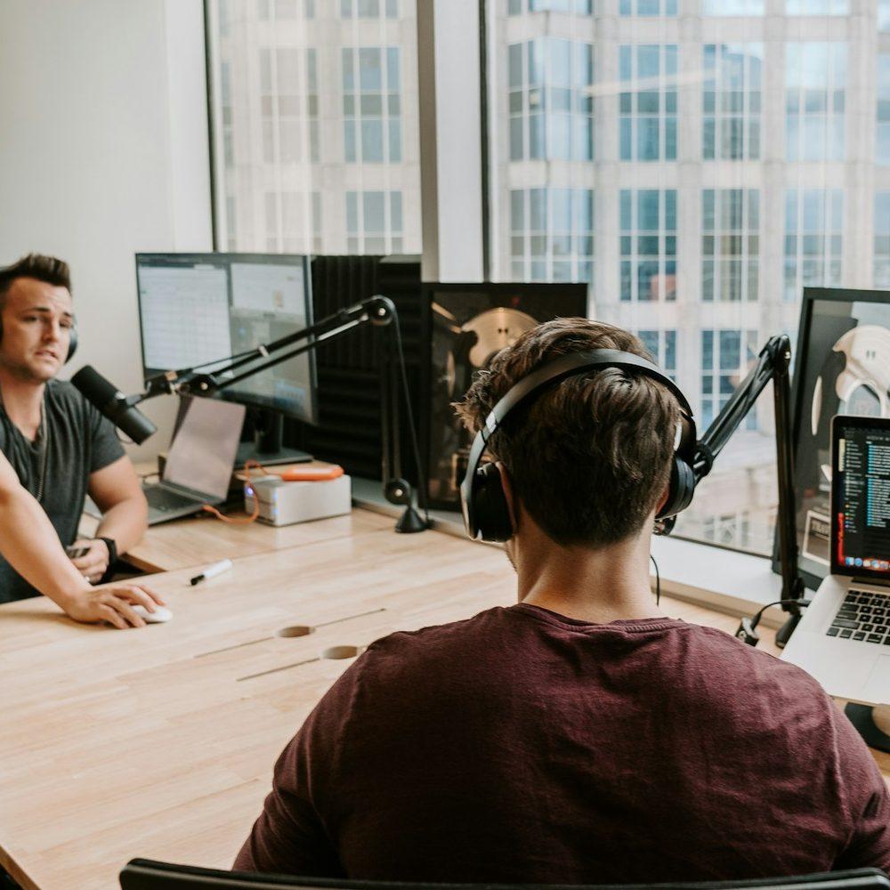 Two podcasters recording an episode in a studio