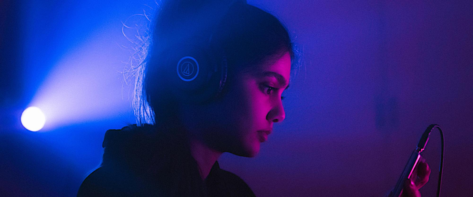 Woman listening to her phone with headphones